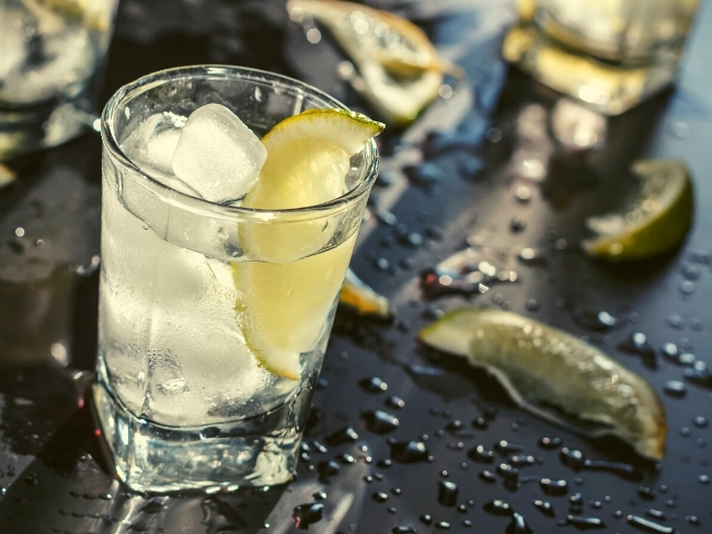 zdjęcie przedstawiające szklankę z drinkiem z lodem i cytryną