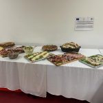 Stół cateringowy z daniami przykryty białym obrusem