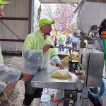 dwóch mężczyzn przy maszynie do napełniania worków sokiem jabłkowym