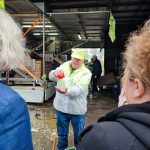 mężczyzna trzymający jabłko stoi na tle hali gospodarczej