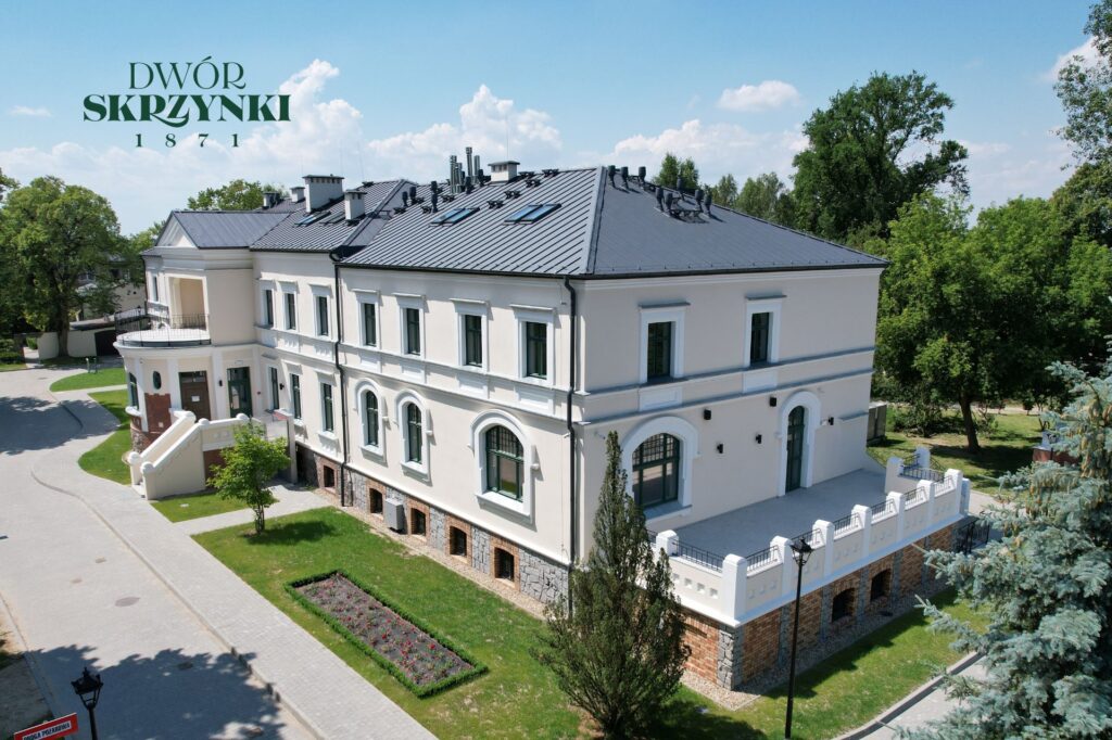 budnek dużego, białego pałacu w otoczeniu parku, kadr z lotu ptaka