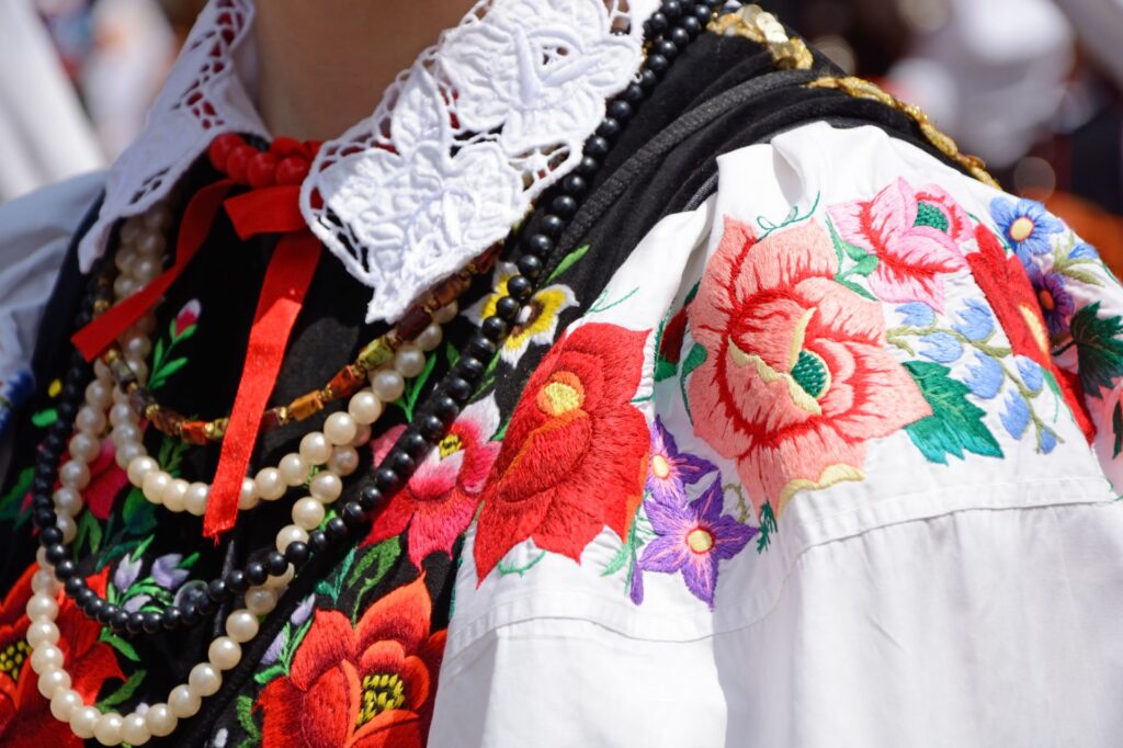 fragment stroju udowego - biała haftowana koszula, serdak, korale