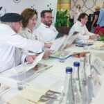czworo członków komisji konkursowe w białych strojach siedzących za wspólnym stołem